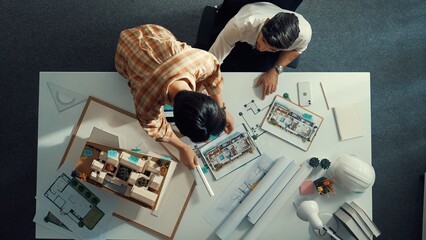 Top down view of skilled business man and colleague design house together. Aerial view of architect...