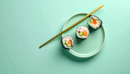 Sushi rolls on a green plate with golden chopsticks, close-up shot