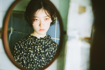 Emotional portrait of person looking into mirror with introspective and cinematic mood