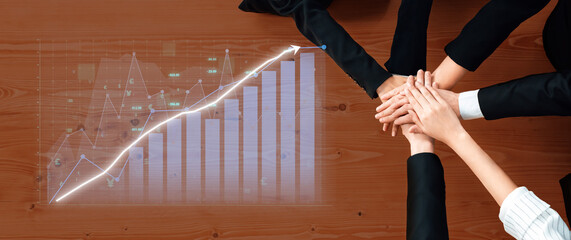 Fototapeta premium Business professionals join hands over a graph chart symbolizing collaboration, strategy, and partnership aimed at achieving growth and success in the office environment. Axiom