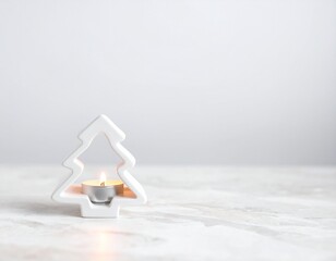 A Christmas tree candle holder glows on a marble surface, indoors.