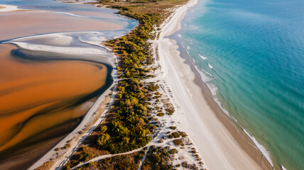 An aerial photograph of a coastal landscape divided into three distinct sections