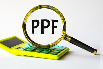 PPF - acronym under magnifying glass on the background of calculator