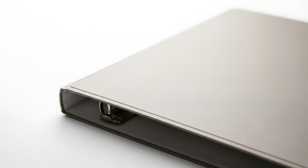 A close up shot of a silver binder with metal rings on a white surface in a studio setting ai generated