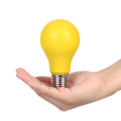 A hand holds a bright yellow lightbulb against a dark background