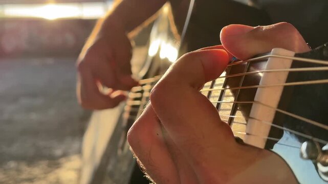 Man plays guitar outdoors. Summer evening