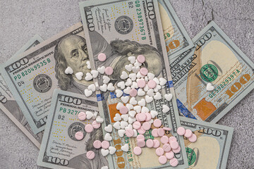 Dollar bill and a set of medicine pills. Rising costs of medical care. Reliefs for buying...