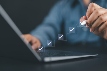 Checklist completion and task progress concept. Man using stylus to check off items on ascending checklist, productivity, task completion, workflow management, and goal achievement in business.