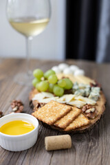 Elegant wine and cheese board with grapes and nuts on rustic wooden table