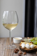 Elegant wine and cheese board with grapes and nuts on rustic wooden table