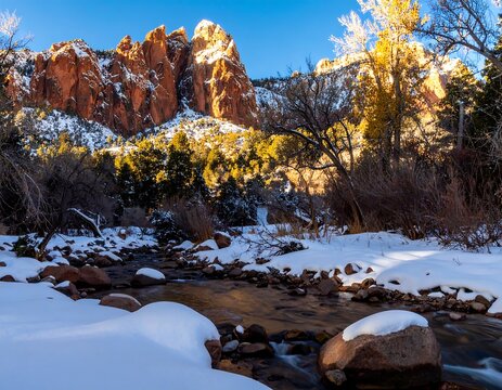 Winter landscape with snow-covered stream and red rock formations