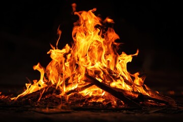 Vibrant flames dancing above black background with glowing embers and charred wood, creating warm atmosphere of coziness and energy in captivating fire composition