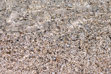 bright abstract background with pebble shore under clear, rippling water with soft patterns. digital art. visual natural design. abstract nature