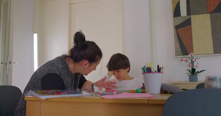Mother trying to help son continue homework as he rubs his eyes, moment of frustration and tiredness, concept of learning challenges, patience and emotional parenting - Powered by Adobe