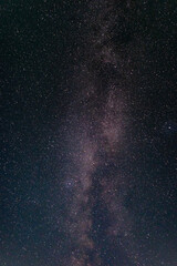 A bright Milky Way stretches across the clear summer night sky