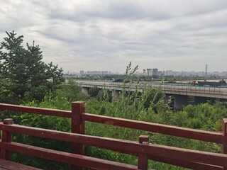 Springtime brings clear skies and lush greenery everywhere; a wooden path leads up the mountain.
