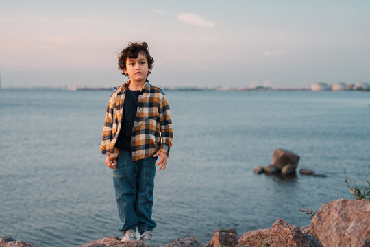 A woman and child pose energetically with a soccer ball, exuding joy and connection against a sky and landscape backdrop.