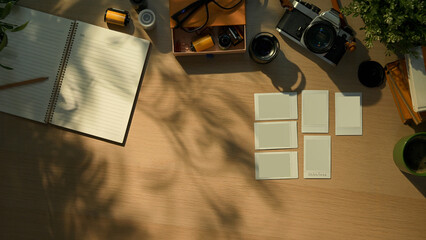Creative workspace with vintage camera, notebook, and coffee cup in warm morning sunlight