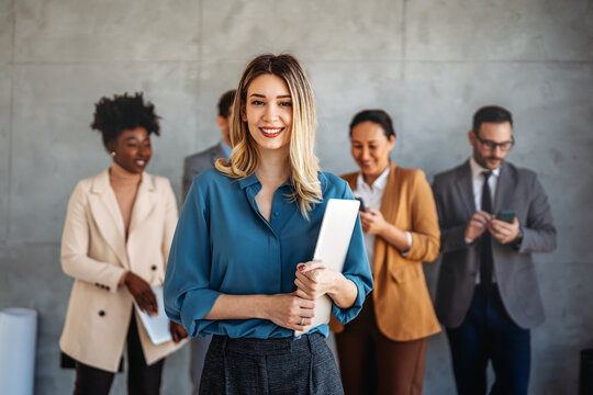 Busy smiling executive business team using digital devices in office. Diverse professional people - Powered by Adobe