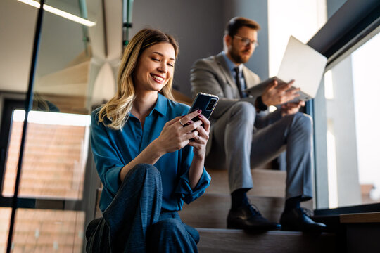 Busy smiling executive business team using digital devices in office. Diverse professional people