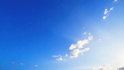 Vast Azure Expanse A high angle, close up shot of a brilliant blue sky with scattered, soft white clouds. The light is bright and even, suggesting a clear day. No objects or hints of human presence.
