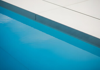 Obraz premium Clean blue water edge with white tiling and reflection