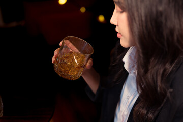 Closeup business woman holding a glass of whiskey