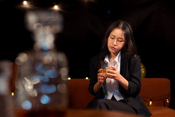  Closeup business woman holding a glass of whiskey