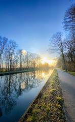 A serene riverside scene at dawn, showcasing the exquisite beauty of nature with its vibrant reflections on water
