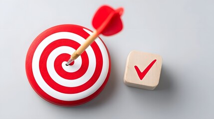 Precision dart strike lands on bullseye of target paired with a wooden cube bearing a checkmark symbolizing achievement confirmation and strategic completion