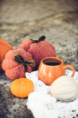 Pumpkin shaped mug of strong black coffee, cozy autumn interior with handmade decorations