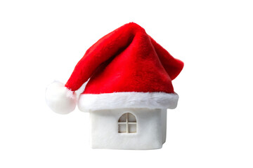 White miniature house with window wearing draped red Santa hat with pompom, isolated on a transparent background