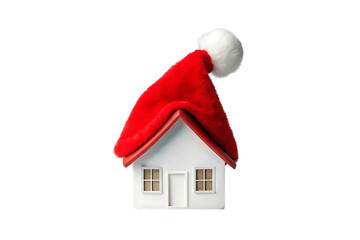 Miniature white house model with red roof wearing festive Santa hat, Christmas holiday decoration concept, isolated on a transparent background