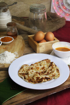 Roti canai sarang burung is a Malaysian street food that takes classic roti canai and shapes it into a "bird's nest" with a cracked egg in the center, which is then cooked. Malaysian Cuisine RotiCanai