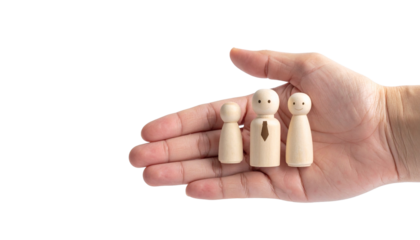 A human hand gently cradles a wooden family, symbolizing care and protection. The wooden figures represent a family unit