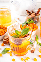 Hot autumn organic drink. Healthy diet beverage, immunity booster food. Sea buckthorn hot tea  drink with orange zest, cinnamon spices and honey in a glass cups