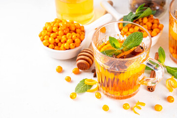 Hot autumn organic drink. Healthy diet beverage, immunity booster food. Sea buckthorn hot tea  drink with orange zest, cinnamon spices and honey in a glass cups