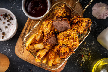 Beef Steak Nuggets Bites in crispy corn breading, cooked in an airfrier grill or oven. Healthy carnivore diet alternative nuggets. With barbecue sauce, spices and french fries potato chips