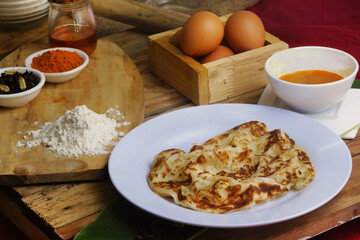roti canai : Flaky Perfection: A light, pan-fried Malaysian flatbread with a crispy exterior and soft, layered interior. Served with our rich, aromatic dhal (lentil) and chicken curry for dipping.