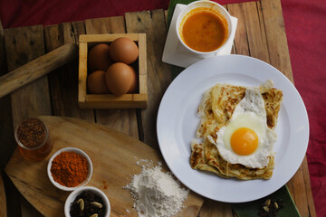 roti canai : Flaky Perfection: A light, pan-fried Malaysian flatbread with a crispy exterior and soft, layered interior. Served with our rich, aromatic dhal (lentil) and chicken curry for dipping.