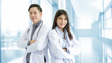 Medicine and healthcare concept : Happy and cheerful Asian doctors, Male and Female holding files with stethoscope and smiling in lobby of hospital. COPY SPACE.