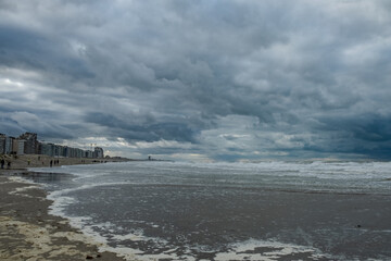 Nieuwpoort, West-Vlaanderen, Belgium, Ocotber 25th, 2025, vast and desolate beachscape under heavy cloud cover with textured wet sands and feeling