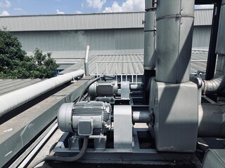 Industrial HVAC motors and ventilation units are installed on a factory rooftop. Equipment features...