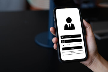 A person holding a smartphone showing a login and registration screen interface. Concept of online account access, cybersecurity, data privacy, and mobile application user authentication system.