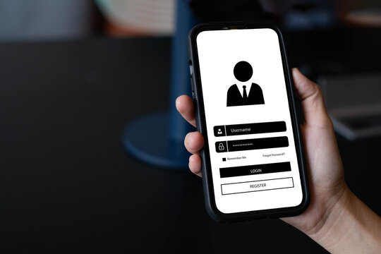 A person holding a smartphone showing a login and registration screen interface. Concept of online account access, cybersecurity, data privacy, and mobile application user authentication system.