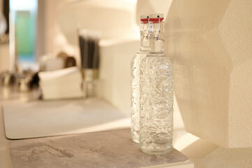 stylish glass bottles with patterned design stand elegantly on marble countertop in modern kitchen setting. soft lighting enhances minimalist aesthetic, creating upscale ambiance