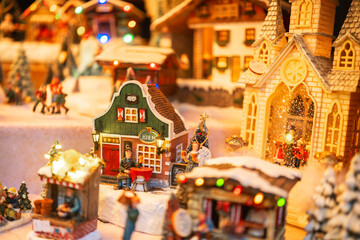 Miniature winter village with festive lights and tiny people enjoying seasonal scenes