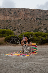Woman with mobile phone on the beach.