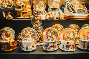 Collection of festive snow globes with Santa Claus and snowmen inside, on display.