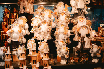 Collection of festive Santa Claus figures displaying winter gear and charming wooden buildings.